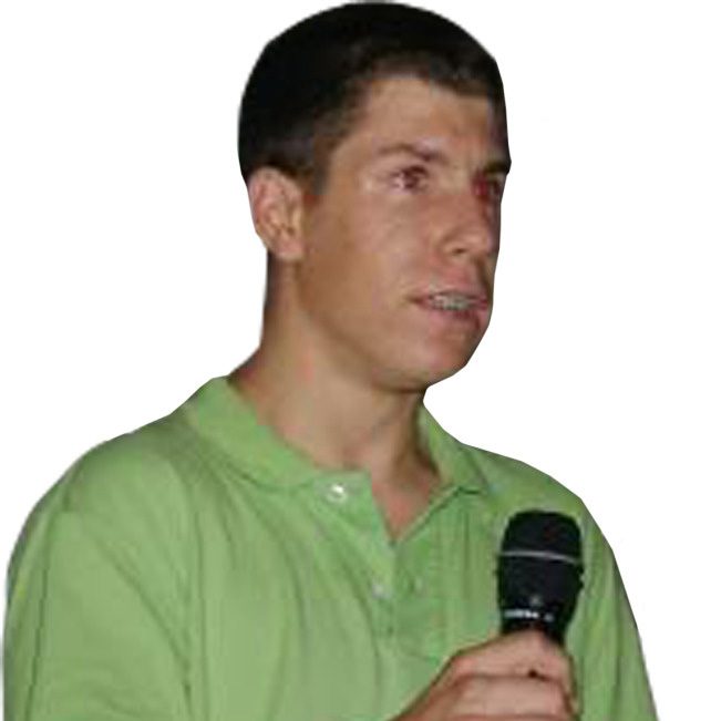 Young man in green shirt holding a microphone.