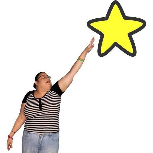 A woman reaching for a star above her.